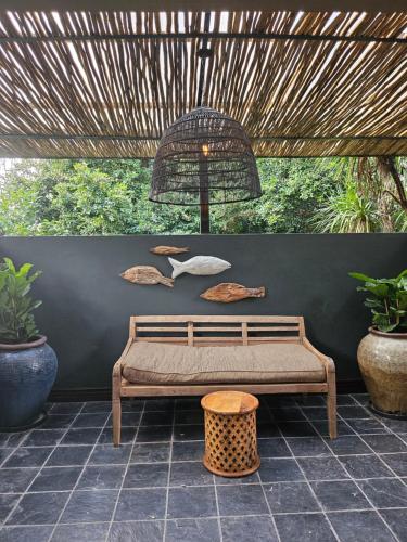 a bench under a pergola with a table and a basket at The Residence in Johannesburg