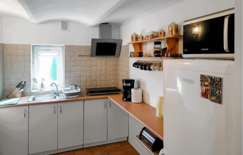 a kitchen with white cabinets and a white refrigerator at Stunning Apartment In Huta Gorna in Huta Górna