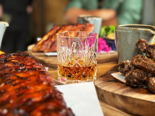 a table topped with meat and a glass of drink at The Stroud Hotel in Stroud