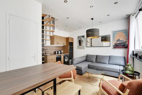 un salon avec un canapé et une table dans l'établissement Pick A Flat's Apartments in Montmartre - Rue des Cottages, à Paris