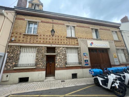 two motorcycles parked in front of a brick building at Jolie chambre sous les toits in Dreux