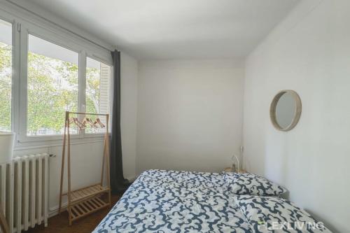 une chambre avec un lit, un miroir et une fenêtre dans l'établissement Flexliving - room - Verdun, à Paris