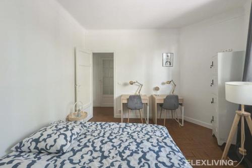 - une chambre avec un lit et un bureau avec deux chaises dans l'établissement Flexliving - room - Verdun, à Paris