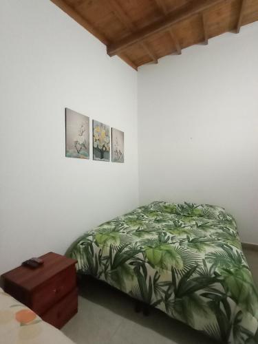 a bedroom with a bed and two pictures on the wall at Villa del Socorro in Jardin