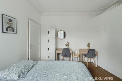 - une chambre avec un lit et un bureau avec deux chaises dans l'établissement Flexliving - room - Lemoine, à Paris