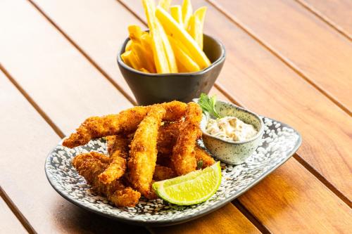a plate of food with fried calamari and a bowl of fries at Novotel Recife Marina in Recife