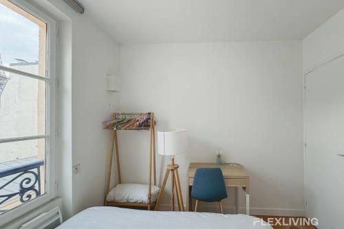 une chambre avec un lit, un bureau et une fenêtre dans l'établissement Flexliving - room - Augereau, à Paris