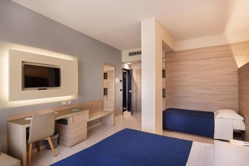 a bedroom with a bed and a desk and a tv at President Park Hotel in Acitrezza