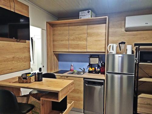 een keuken met een roestvrijstalen koelkast en houten kasten bij Mobile Home Elica, Pirovac in Pirovac
