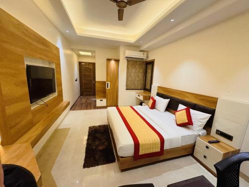 a hotel room with a bed and a television at Hotel MASAGA by QCENT in Gurgaon