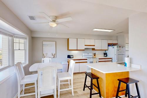 a kitchen with white cabinets and a table and chairs at Snapper #18B-CAC in Buxton