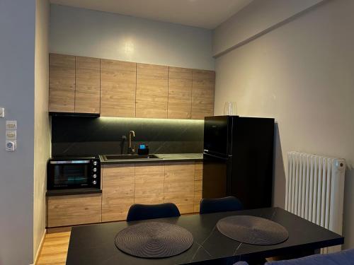 a kitchen with a table and a black refrigerator at Ikia Mia Centrale in Rethymno Town