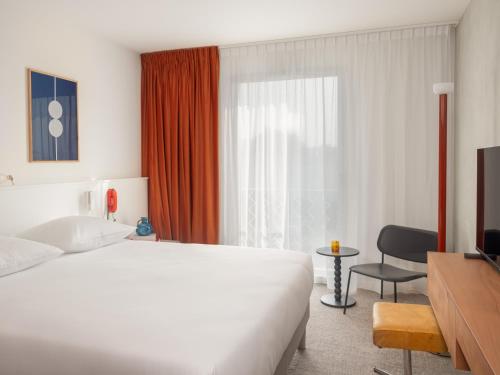 a hotel room with a bed and a window at Hôtel Vertime in Les Sables-dʼOlonne