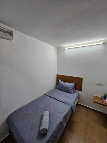 a bedroom with a bed with a pillow on it at New Mawlaya Hotel Penang in Gelugor