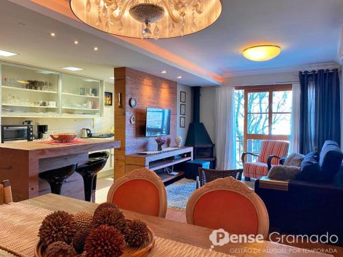 a living room with a dining table and a kitchen at Apartamento a 300m da Rua Coberta de Gramado in Gramado