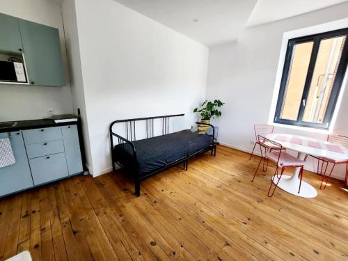 Cette chambre comprend un lit, une table et un bureau. dans l'établissement Appartement à 2 pas des thermes, à Royat