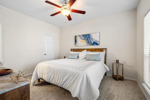 a bedroom with a bed with a ceiling fan at Upscale City Apartment with Pool , Fitness Center in Carrollton