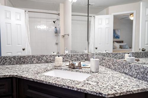 a bathroom with a sink and a large mirror at Upscale City Apartment with Pool , Fitness Center in Carrollton