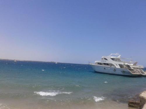 a boat docked in the water next to a beach at Desert Rose Apartment in Hurghada