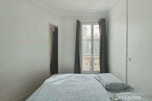 une chambre avec un lit et une fenêtre dans l'établissement Flexliving - whole flat - Lemoine, à Paris