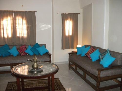 a living room with two couches and a table at Desert Rose Apartment in Hurghada