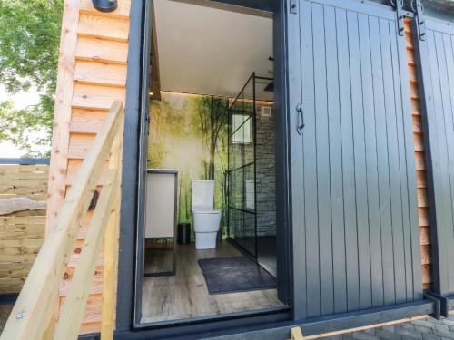 a bathroom with a sliding glass door and a staircase at Hawkstone in Market Drayton