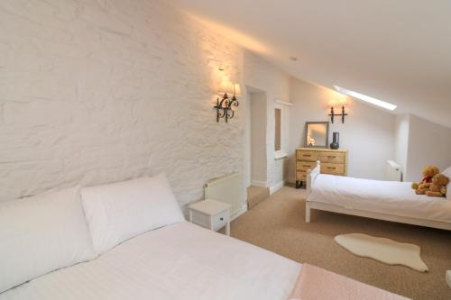 a bedroom with two white beds and a white wall at Ellenor in Kingsbridge