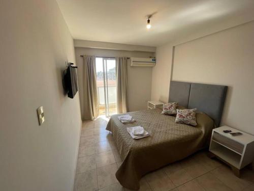 a bedroom with a bed with two pillows on it at Dpto en av mate de luna a estrenar in Villa Luján