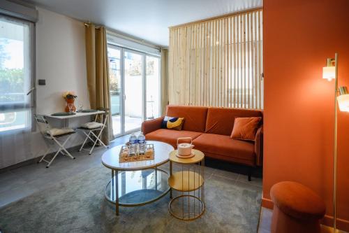 a living room with a couch and a table at Le Terra Rosa ~ Parking ~ Proche Airbus in Colomiers