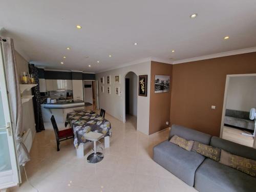 Il comprend un salon et une cuisine avec une table et un canapé. dans l'établissement Le Lotus - appartement, à Béziers