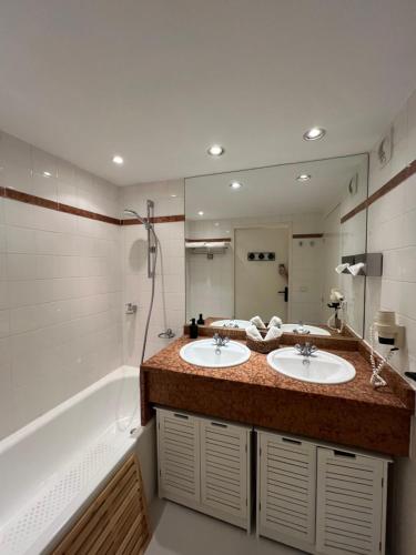 une salle de bain avec deux lavabos et un grand miroir dans l'établissement Appartement piscine tennis, à Mandelieu-la-Napoule