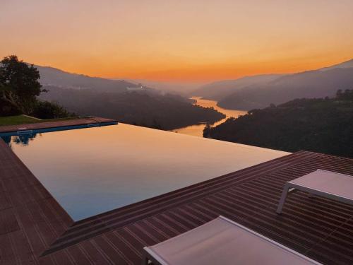 a swimming pool with a view of a river at Douro Mesio Guest House in Resende