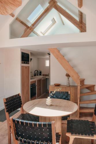 une cuisine et une salle à manger avec une table et des chaises dans l'établissement La Cabane - Gîtes des Havres, à Gouville-sur-Mer