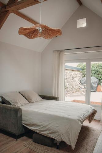 une chambre avec un lit et un ventilateur de plafond dans l'établissement La Cabane - Gîtes des Havres, à Gouville-sur-Mer