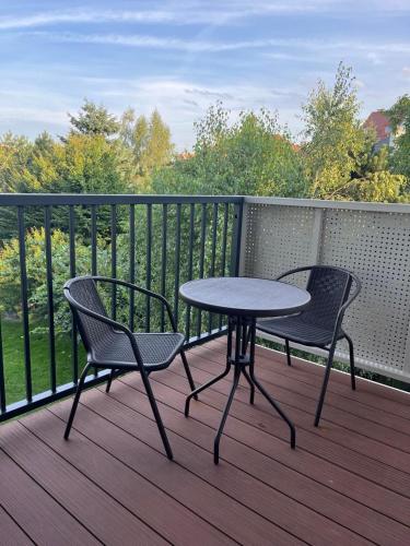 a table and two chairs on a deck with a table at Apartament Andrea in Oleśnica
