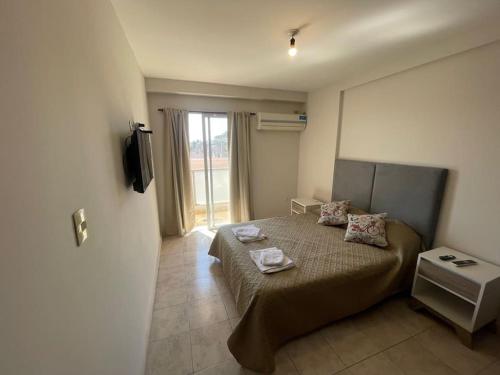 ein Schlafzimmer mit einem Bett mit zwei Kissen darauf in der Unterkunft Dpto en av mate de luna, en el medio de la ciudad in Villa Luján