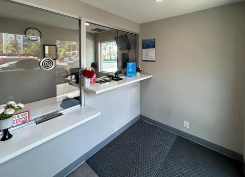 a waiting room with a counter and a window at Studio 6 Suites Santa Ana, CA in Santa Ana