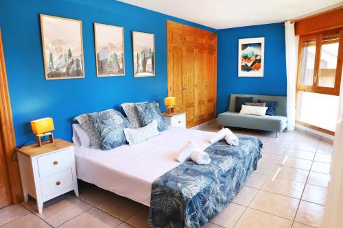 a bedroom with a bed and a blue wall at Villa San Lure Jaca in Jaca
