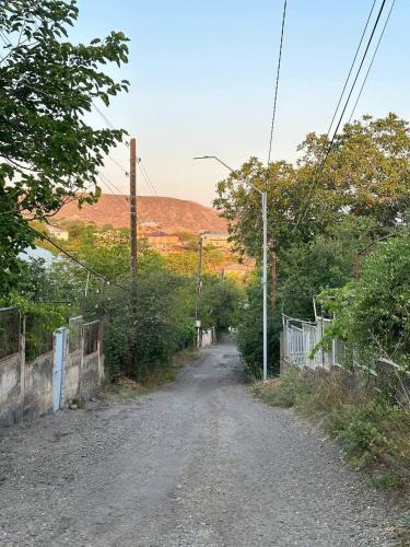 a dirt road with a fence and a hill at B&B Ruzan in Yeghegnadzor