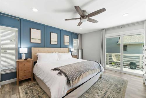 a bedroom with blue walls and a bed with a ceiling fan at Beachside Vilano Lux Arcade Pets 6min to Historic in Vilano Beach