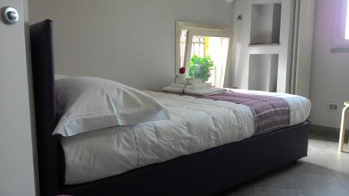 - une chambre avec un lit doté de draps blancs et une fenêtre dans l'établissement Mansarda Palatina, à Turin