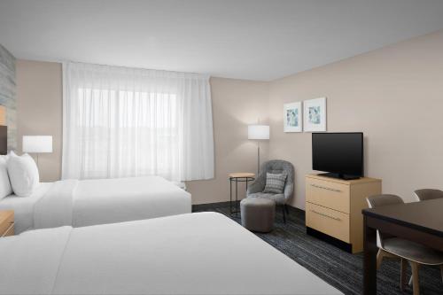 a hotel room with two beds and a flat screen tv at TownePlace Suites by Marriott Goldsboro in Goldsboro