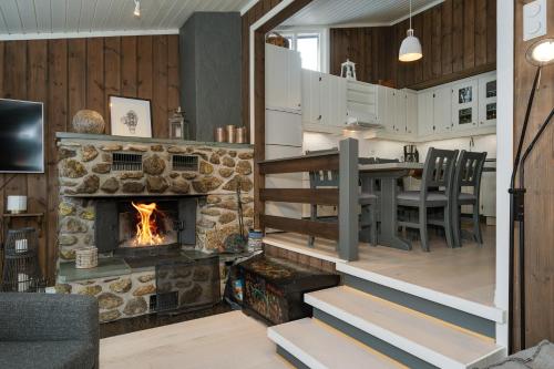 a kitchen and living room with a stone fireplace at Bitigrenda K in Beitostøl