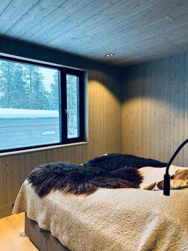 una camera da letto con un letto in una stanza con una finestra di Eksklusiv hytte ved Fyri Resort - Utsikt a Hemsedal