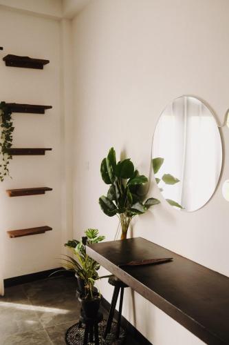 a mirror and a table in a room with plants at The Jini House in Ahangama