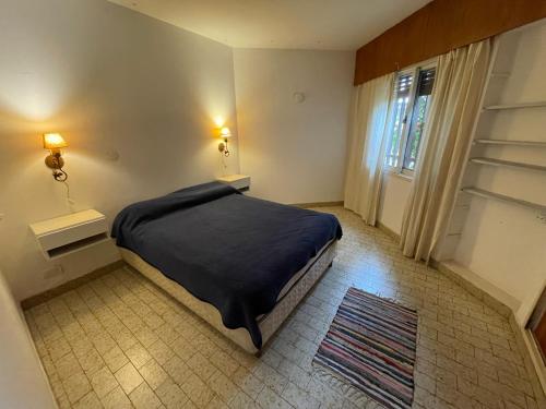 una camera da letto con un letto con un piumone nero e una finestra di Agasajo V a Córdoba