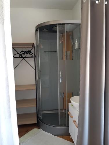 une douche en verre dans une salle de bain avec un lavabo dans l'établissement Chambre chez l'habitant, à Péronne