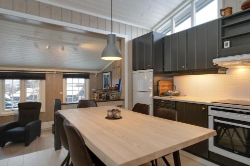 a kitchen with a wooden table and a dining room at Bitigrenda L in Beitostøl