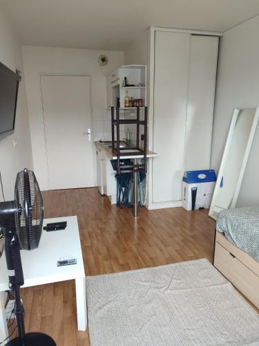 - un salon avec un ventilateur sur le parquet dans l'établissement logement calme proche de paris, à Créteil