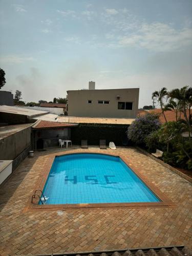 a large blue swimming pool in front of a house at Hotel Santa Catarina in Três Lagoas